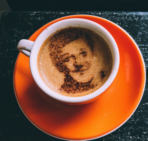 Coffee with image of face stenciled onto it with cocoa